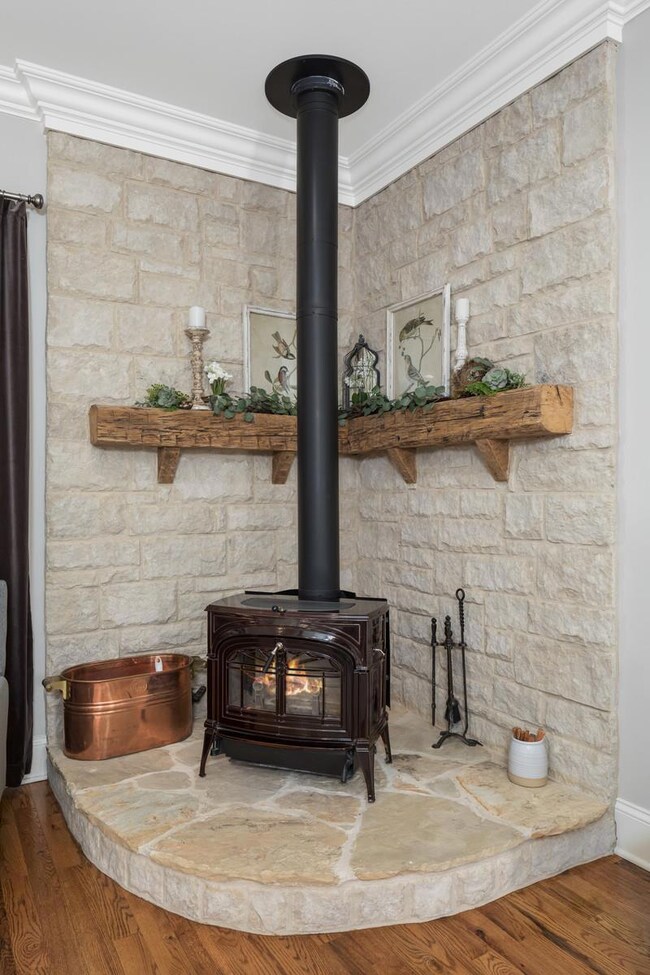 Vermont Castings wood burning stove with solid rock surround and hearth in the living room.