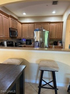 Kitchen featuring refrigerator, arched walkways, s