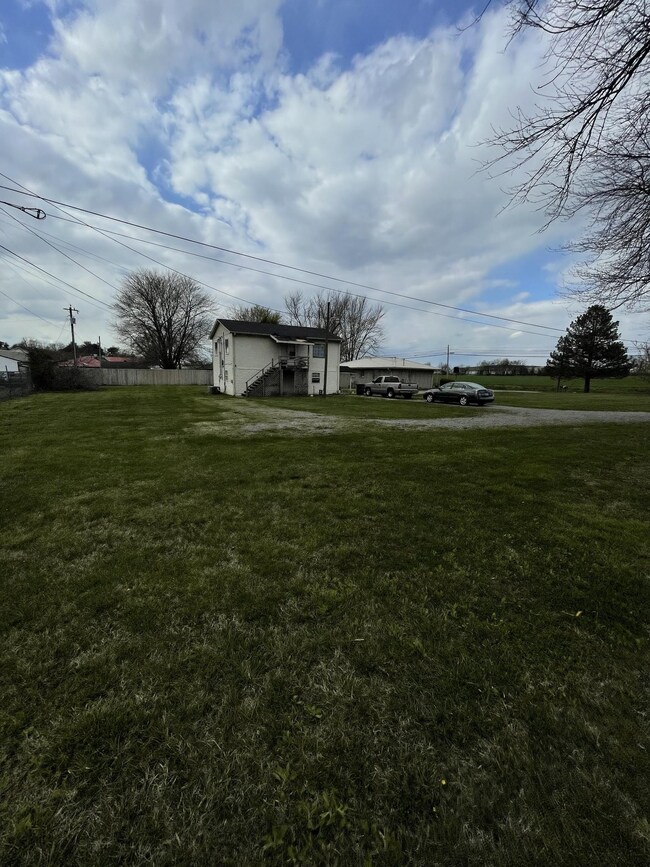 Another side view of apartment building and home. This picture depicts the lot to the left of the property which is included in the sale. 