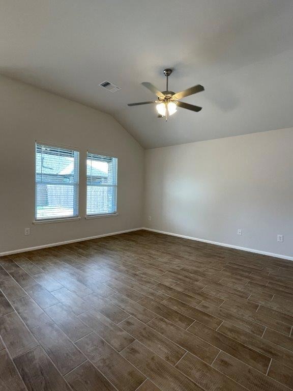 Spare room with lofted ceiling, dark wood finished floors, and ceiling fan