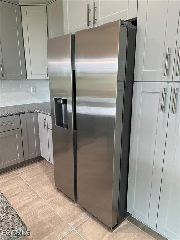 Kitchen with stainless steel fridge, stone counter