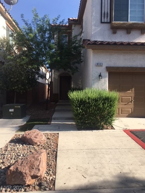 Entrance to property with a garage, stucco siding,