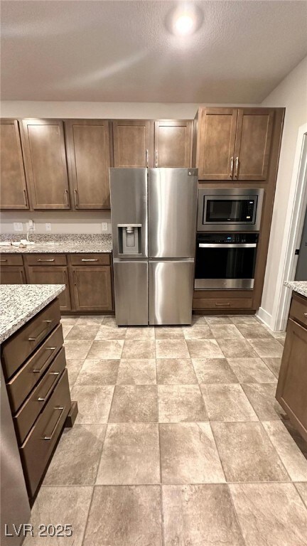 Kitchen featuring a textured ceiling, appliances w