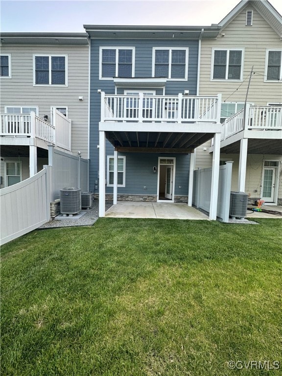 Back of property with cooling unit, a patio area, and a yard