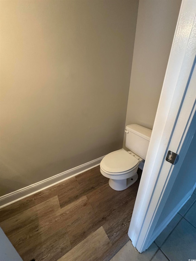 Bathroom featuring wood finished floors, toilet, a