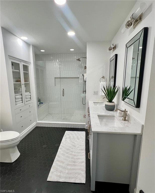 Bathroom with vanity, toilet, and an enclosed show