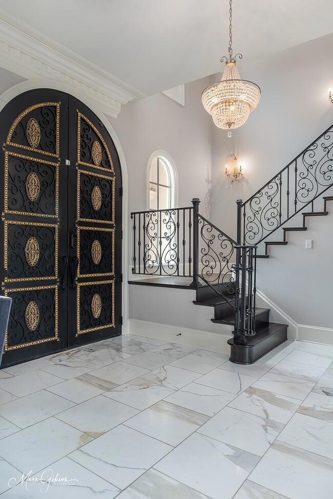 Stairs with a notable railing, chandelier, tile fl