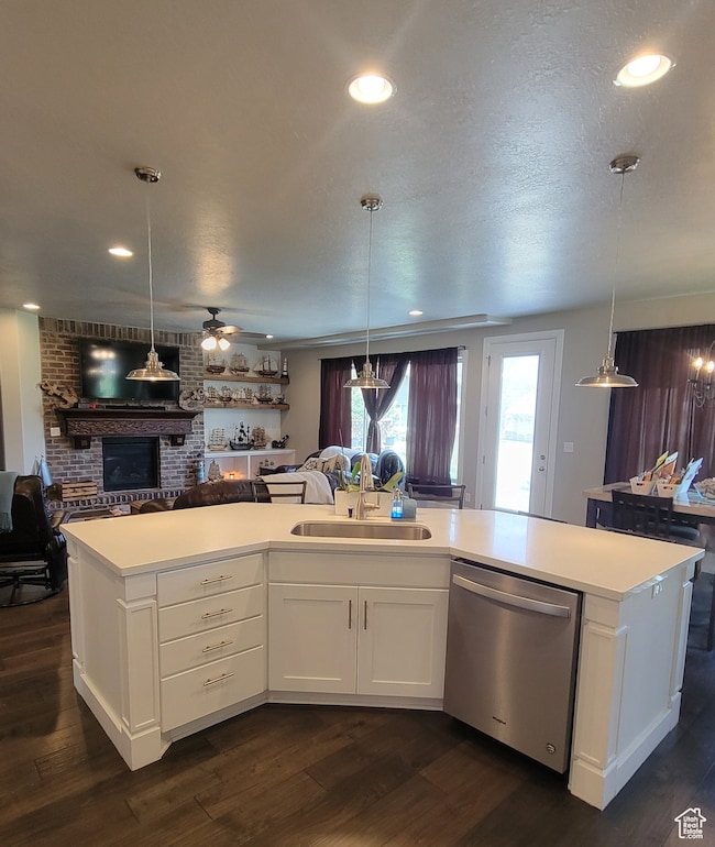 Kitchen with open floor plan, hanging light fixtures, white cabinetry, stainless steel dishwasher, and recessed lighting