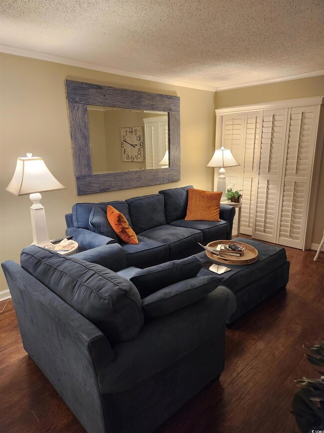 Living room featuring ornamental molding, a textur