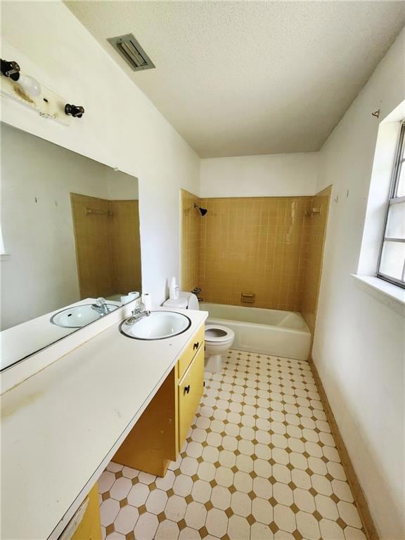 Full bathroom featuring tile patterned floors, vanity, bathtub / shower combination, and a textured ceiling