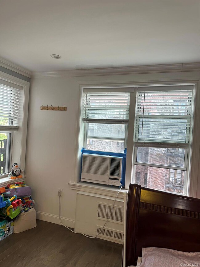 Bedroom featuring dark wood-type flooring and crown molding