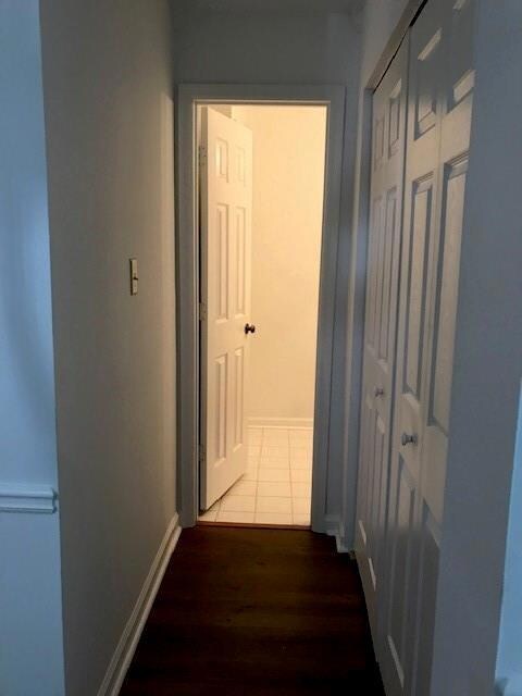 Hallway with hardwood / wood-style floors