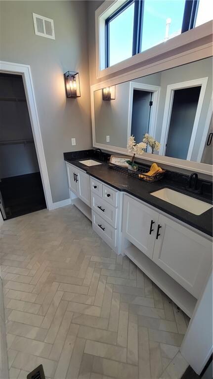 Bathroom with vanity, parquet flooring, and a high ceiling