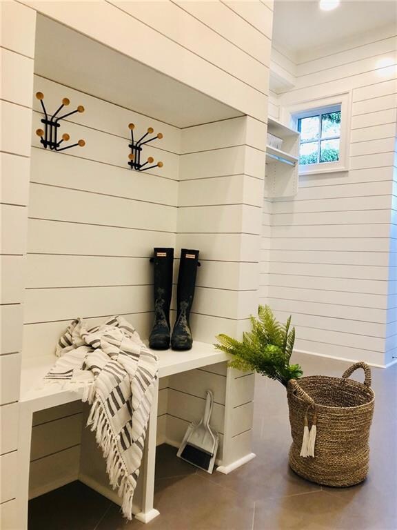 Adorable mudroom includes Shiplap walls, cabinets,