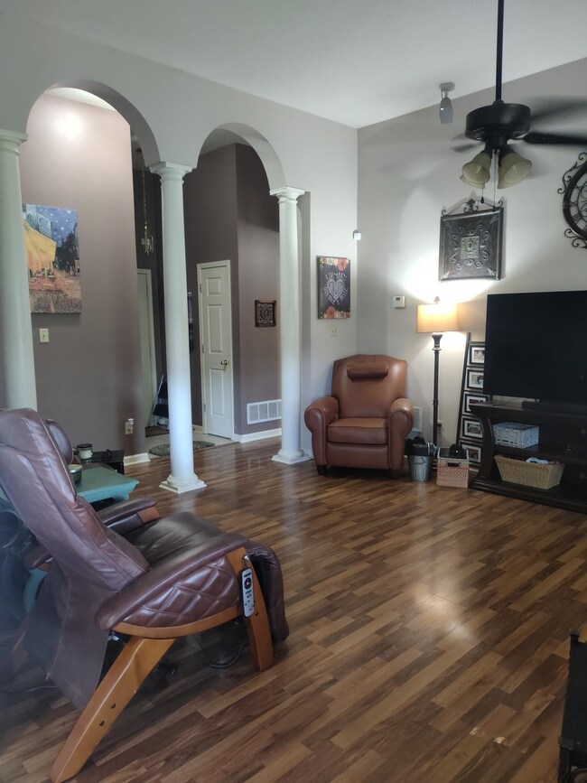 Living room with ceiling fan, decorative columns, 