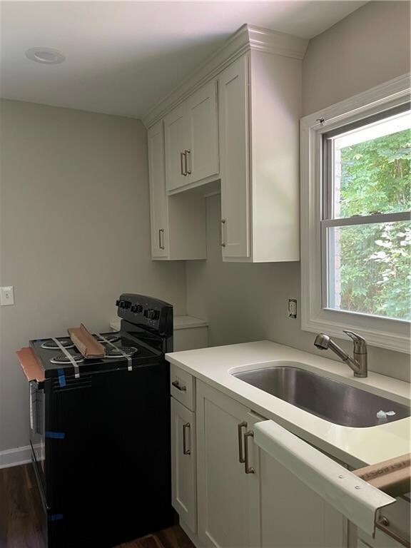 Kitchen featuring range, light countertops, white cabinetry, and dark wood-style floors