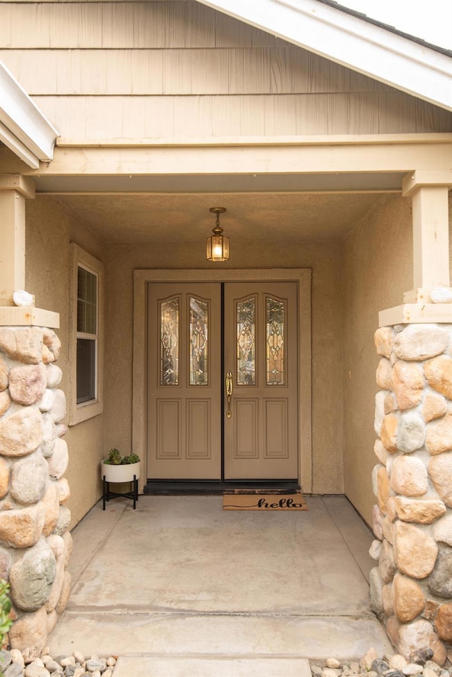 View of exterior entry with stone siding and double door entry.