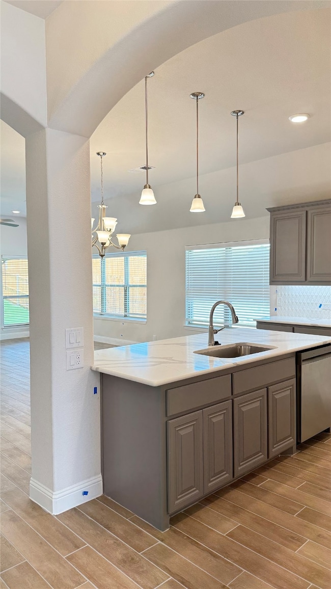Kitchen featuring dishwasher, wood tiled floors, gray cabinets, decorative backsplash, and recessed lighting