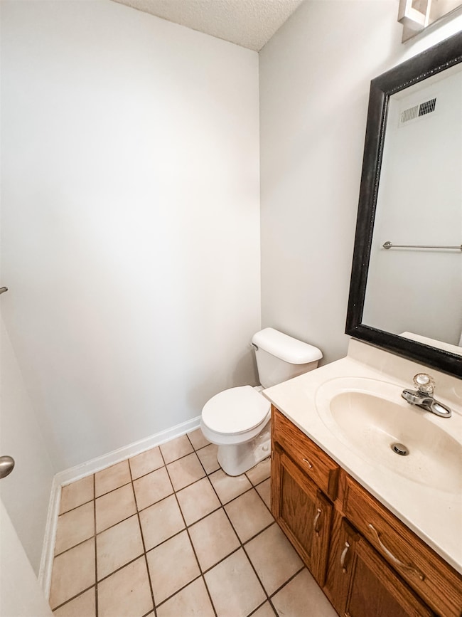 Bathroom featuring vanity, tile patterned flooring, and a textured ceiling
