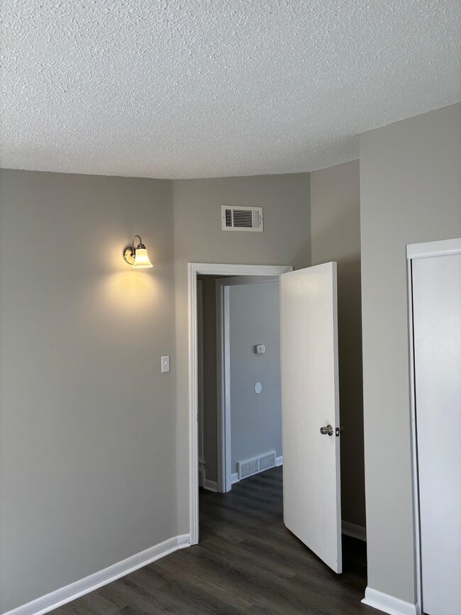Unfurnished bedroom with dark hardwood / wood-styl