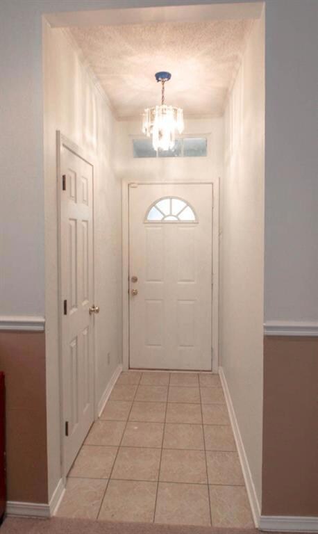 Front hallway has tile and pretty chandelier.