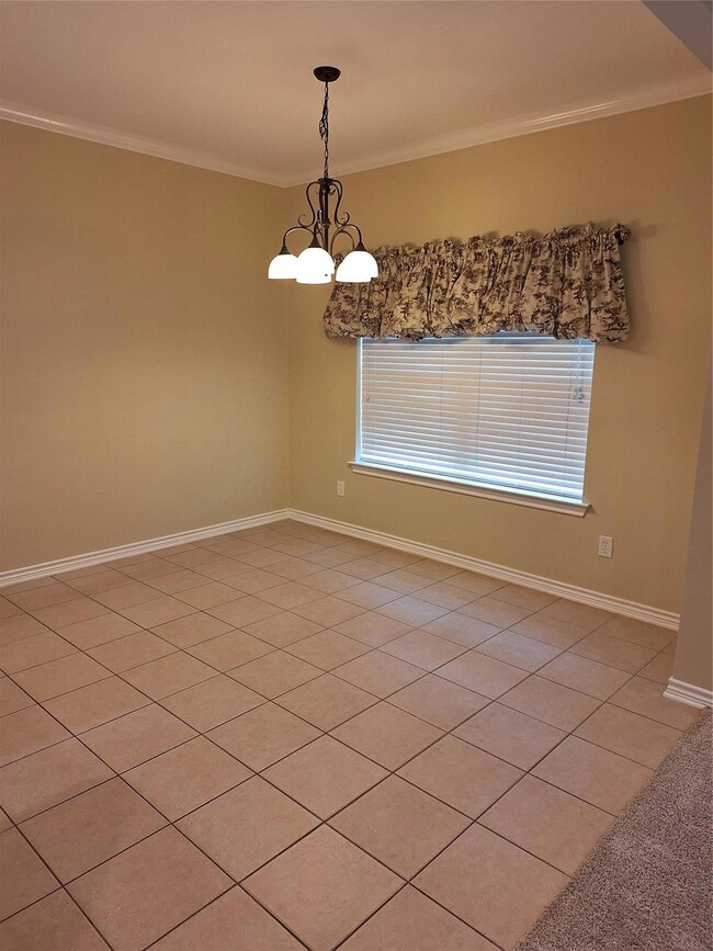 Dining area featuring tile floors, crown molding, 