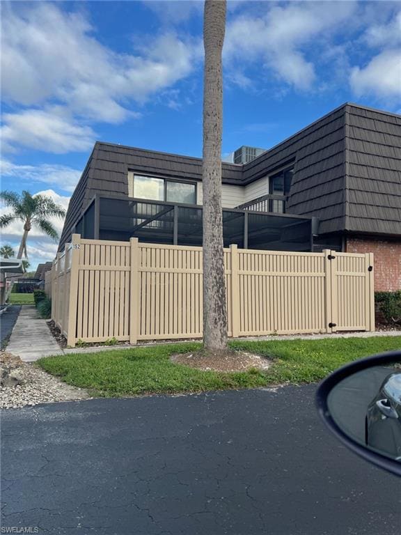 View of home's exterior with mansard roof and brick siding