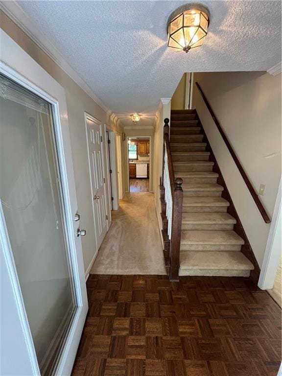 Staircase with a textured ceiling, baseboards, and