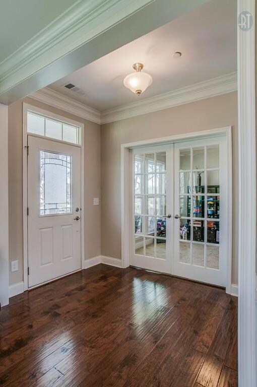 A classic painted front door with lead paned glass invites you into this comfortable home. Warm hardwood flooring flows through-out most of the main level. Notice the transom above the front door. 