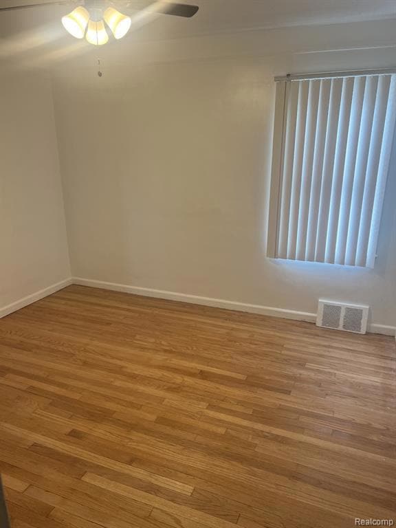 Unfurnished room featuring wood finished floors and baseboards