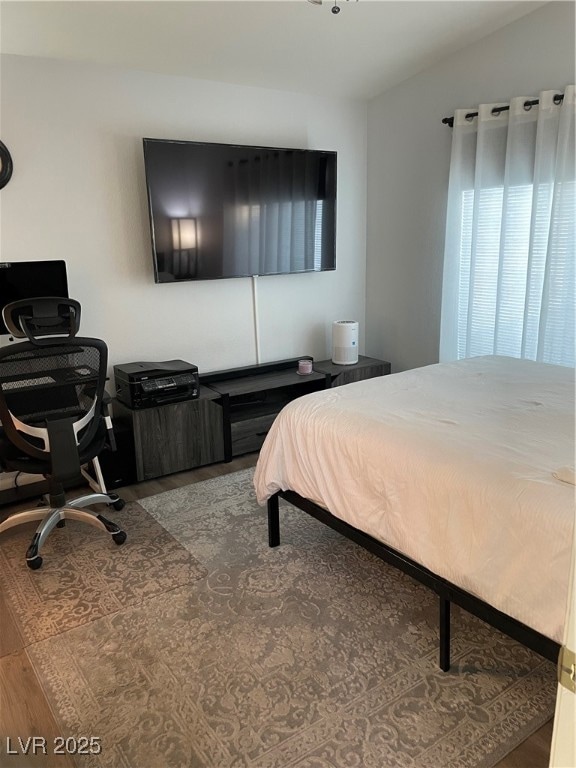 Bedroom featuring wood finished floors and an offi