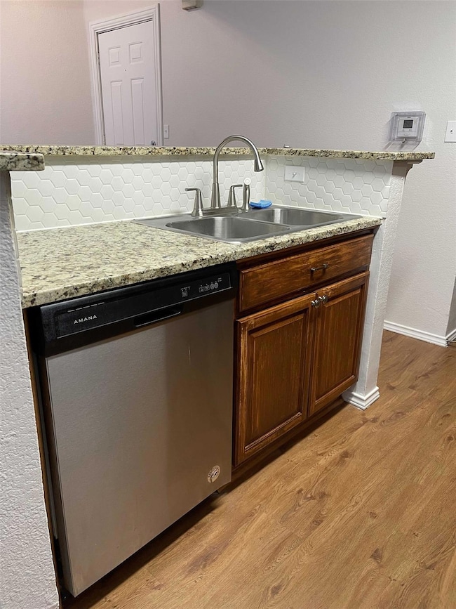 Kitchen with dishwasher, light wood-style floors, 