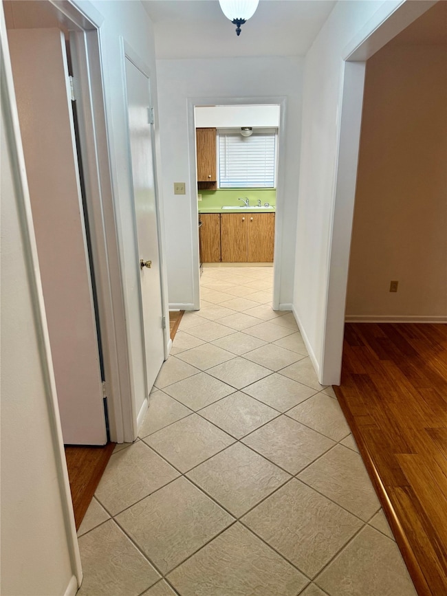 Corridor featuring light tile patterned flooring