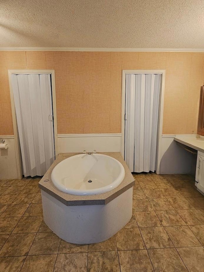Bathroom with ornamental molding, a bath, wainsco