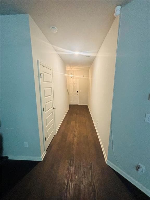 Corridor with wood finished floors and baseboards