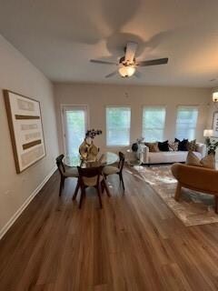 Dining room with dark wood-style flooring, baseboards, and a ceiling fan