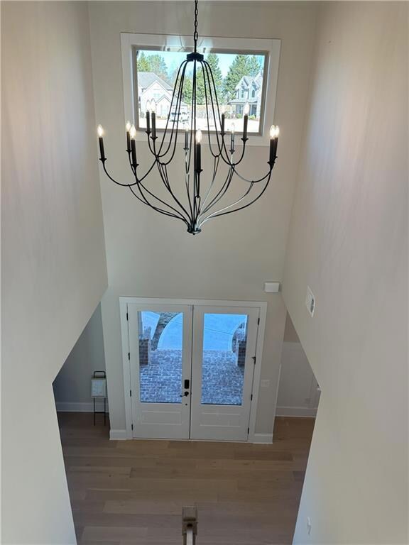 Foyer with french doors, wood finished floors, and a high ceiling