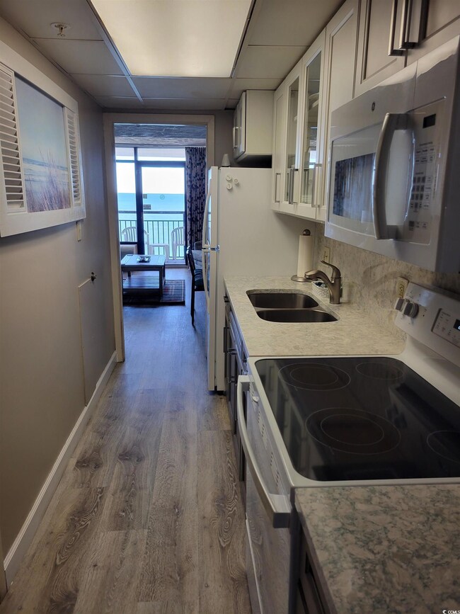 Kitchen featuring stainless steel microwave, glass