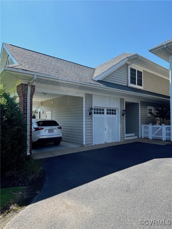 View of side of home featuring a carport and a gar