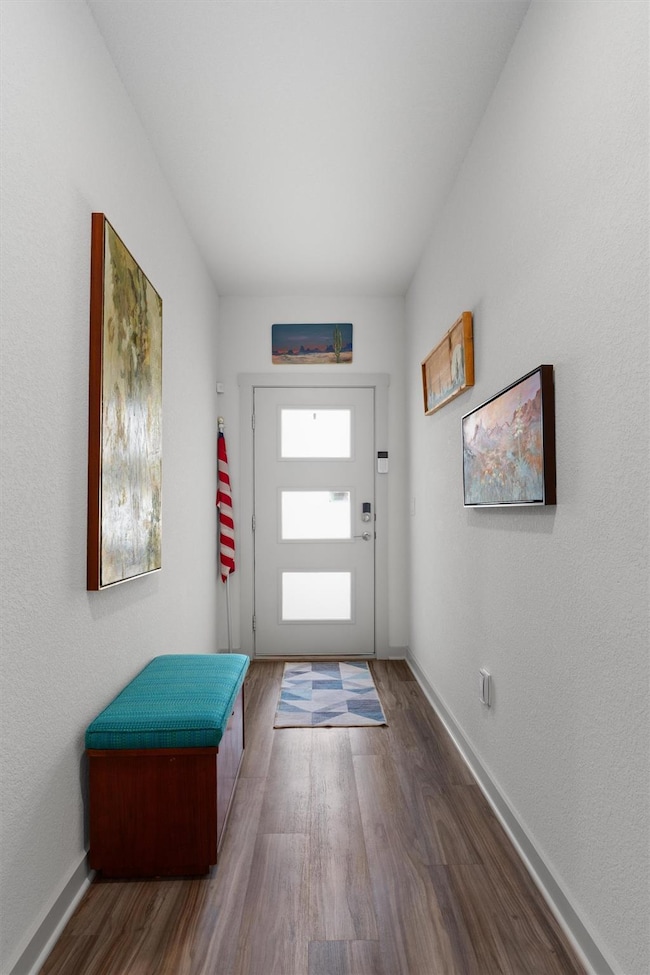 Entryway with dark wood-style floors and baseboar
