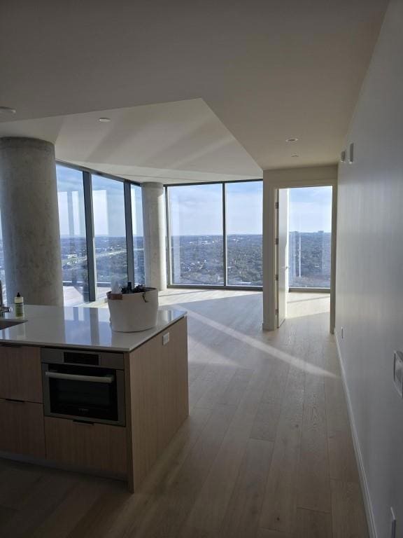 Kitchen with light wood finished floors, baseboar
