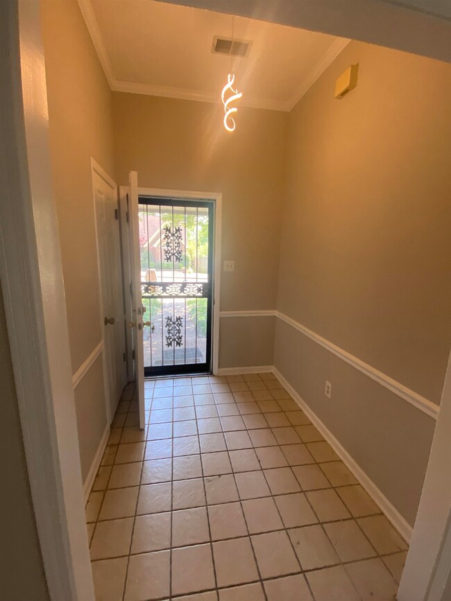 Entryway featuring crown molding, baseboards, ligh