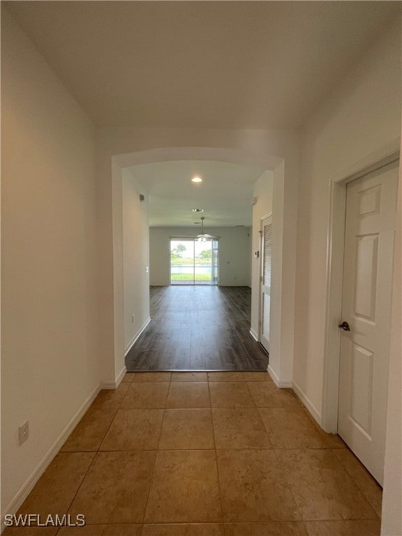 Hallway featuring baseboards and tile patterned floors