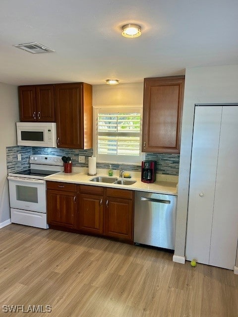 Kitchen with white appliances, a sink, tasteful ba