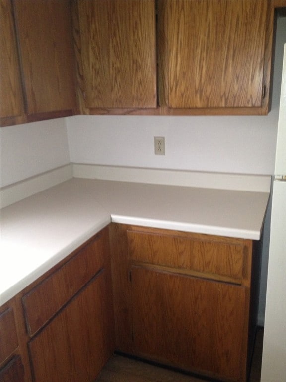 Kitchen featuring light countertops and brown cabi