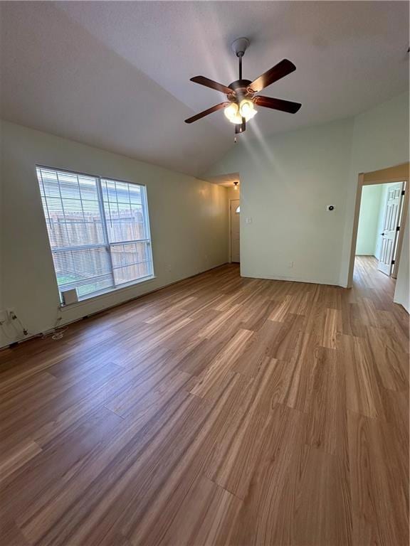 Spare room featuring wood finished floors, ceiling fan, and lofted ceiling