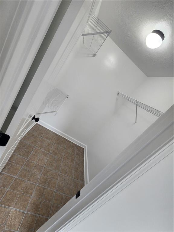 Unfurnished living room with separate washer and dryer, vaulted ceiling, a chandelier, carpet floors, and baseboards
