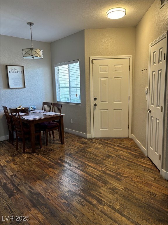 Dining area featuring dark wood finished floors, a