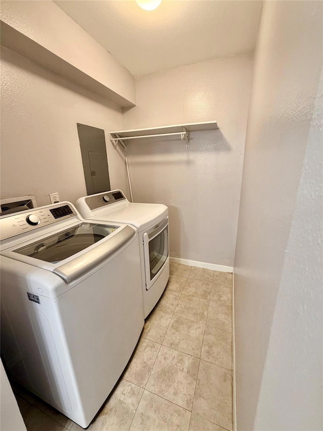 Laundry room featuring a textured wall, washing m