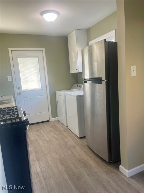 Washroom featuring light wood finished floors and washing machine and dryer